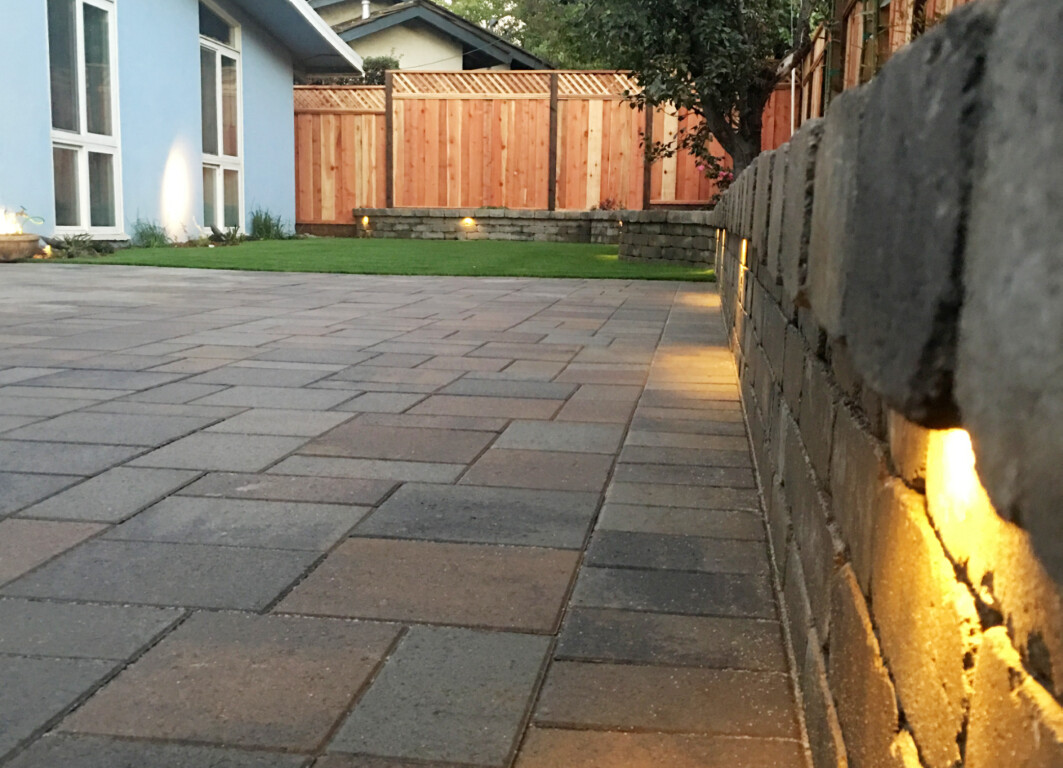 Concrete patio with decorative retaining wall and lighting in Harlingen